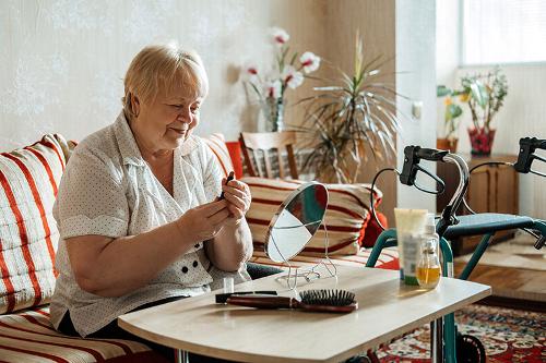 older lady applying lipstick