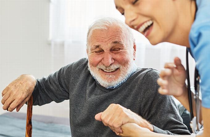 Man laughing with carer