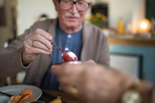man spooning jam out of dish
